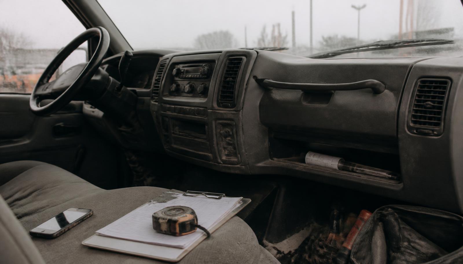 Work van cab with a phone and clipboard left on the passenger seat